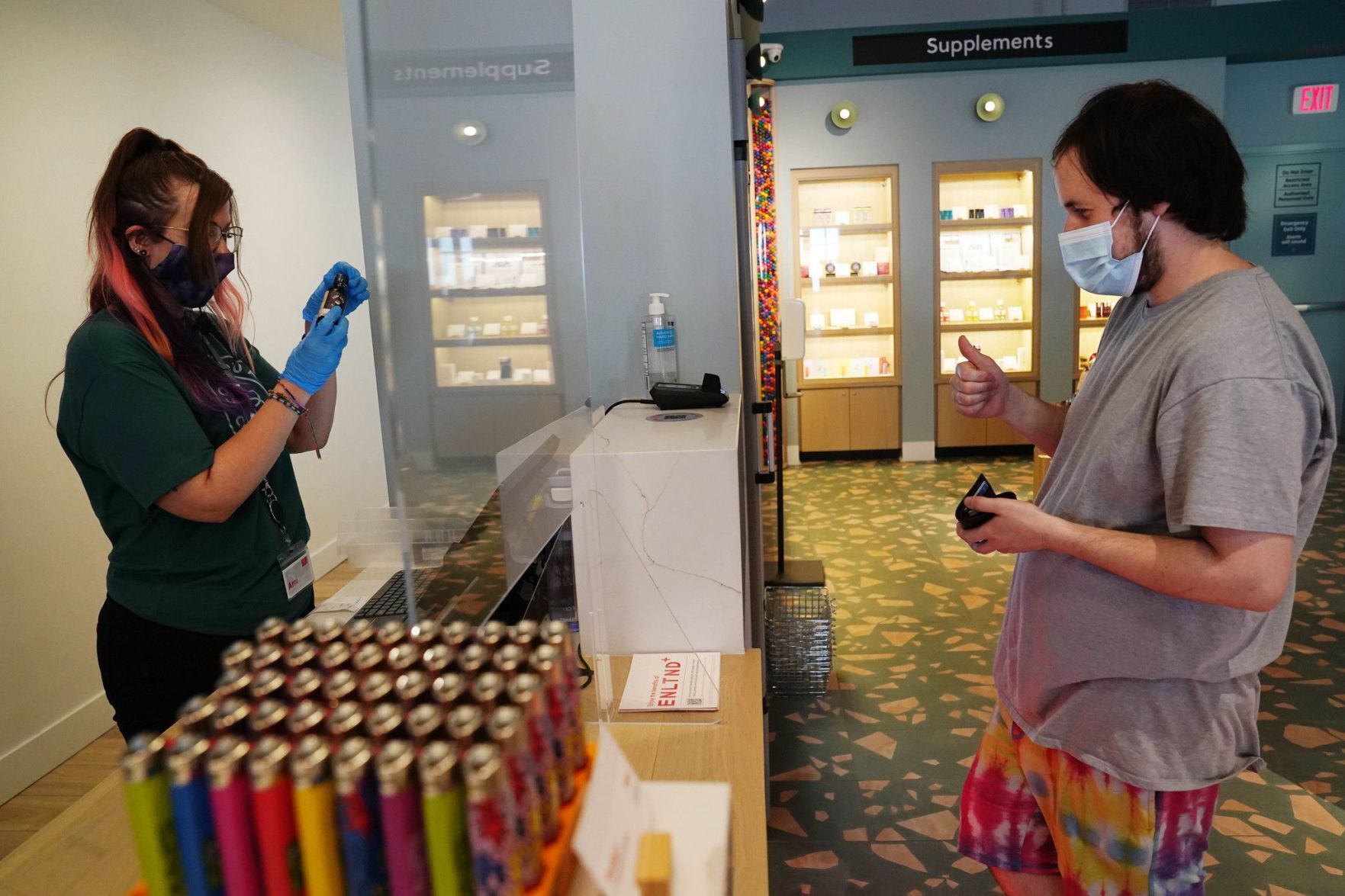 Ami Schneider rings up purchases for a customer at Enlightened Schaumburg dispensary, May 3, 2021.